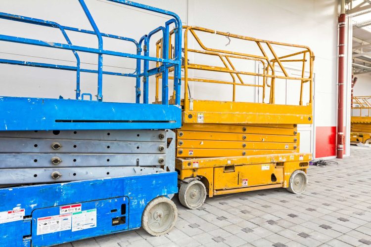 Two narrow aisle scissor lifts indoors on tile flooring