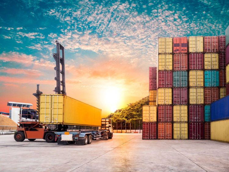Shipping container forklift unloading cargo from a semi-truck