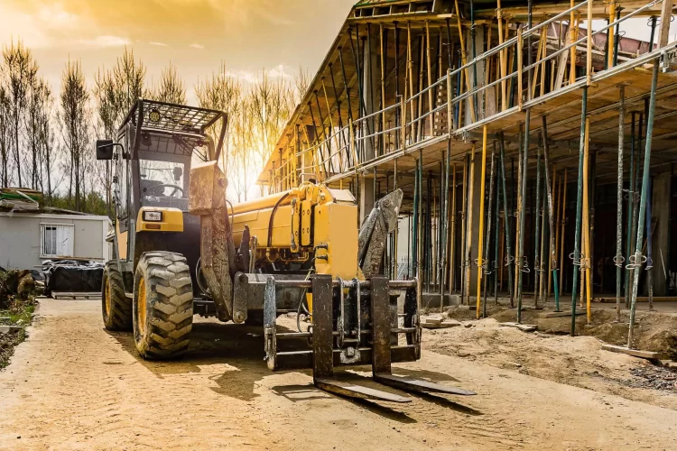 Large yellow telehandler forklift outside at a construction site
