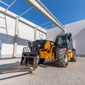 Industrial warehouse construction. Rotating telehandler vehicle. Building a new hall or storehouse.